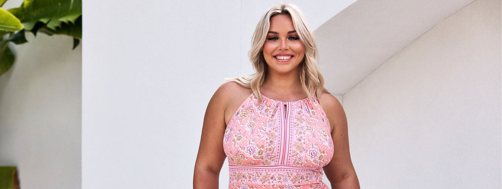 Woman with blonde hair wears pink floral high neck swimsuit