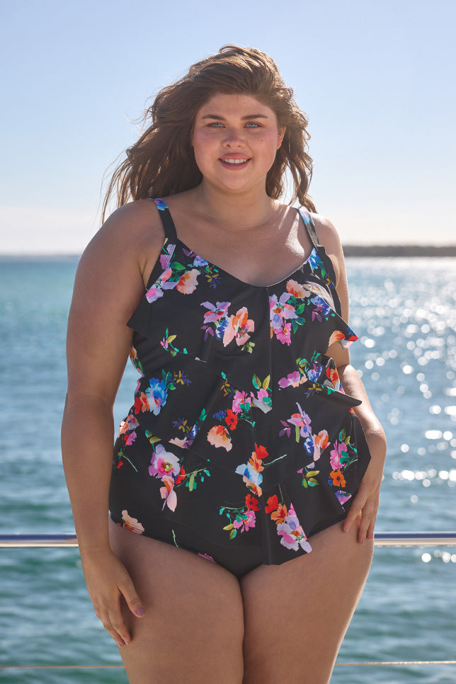 Model wearing black floral ruffle tankini with high waisted pant