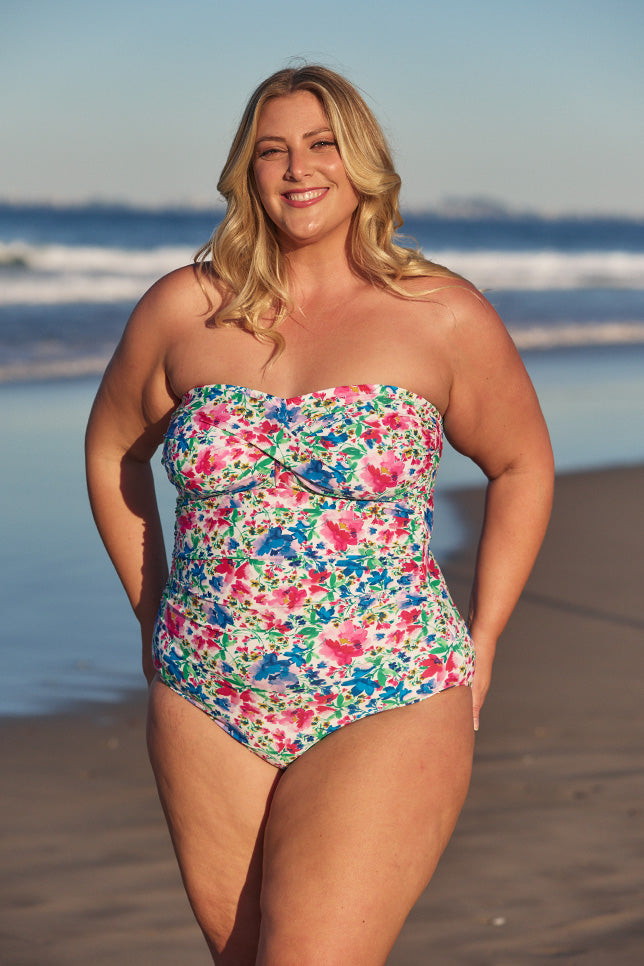 Model wearing multi-coloured floral strapless swimsuit at beach 