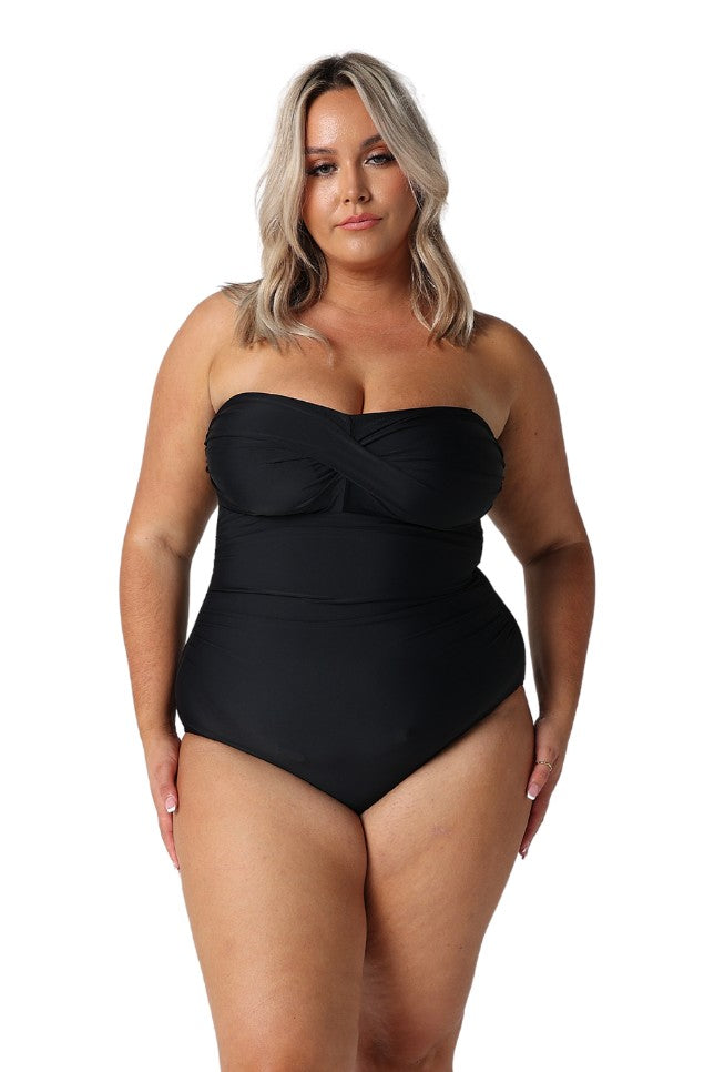 Model wearing black strapless bandeau one piece swimsuit