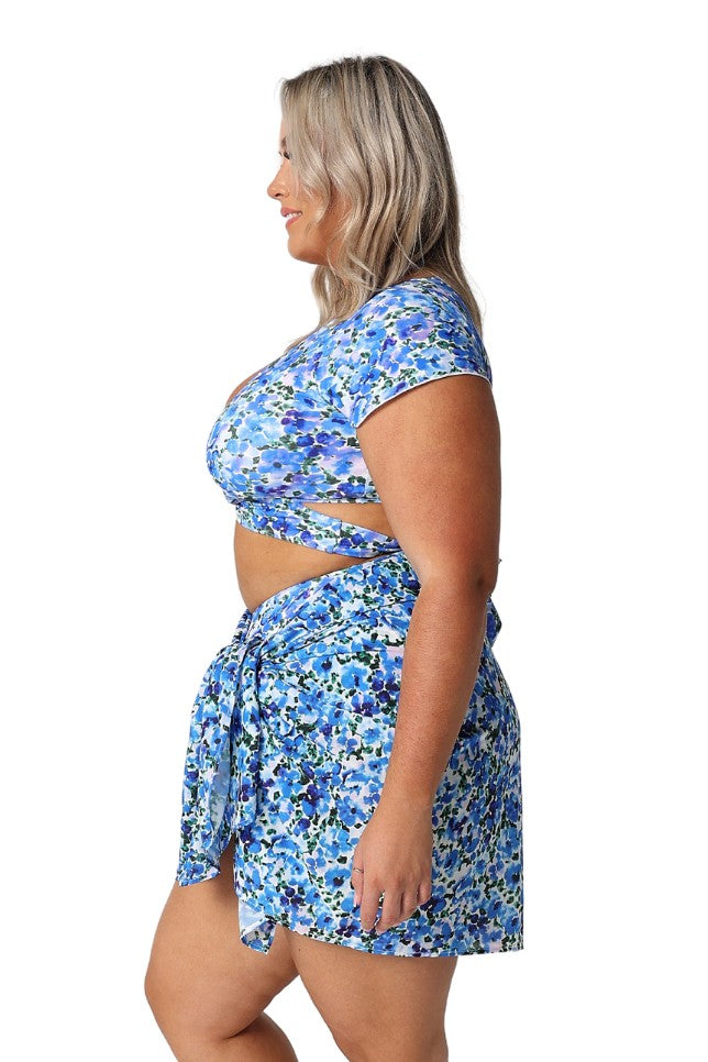 Model showing side of blue floral sarong and matching bikini underneath