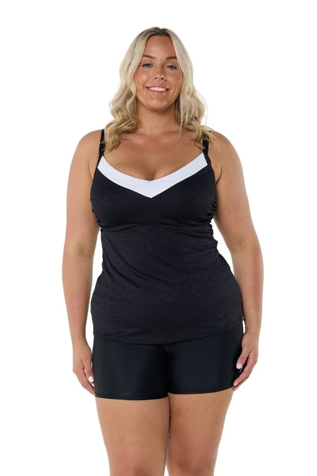 Model wearing black and white underwire tankini top with black swim shorts