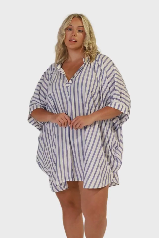 Model wearing navy and white striped beach cover up