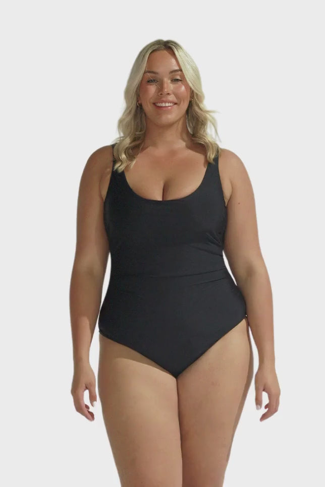 Blonde model wearing black scooped one piece