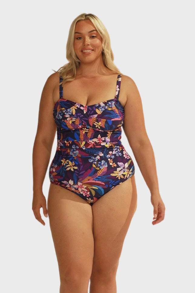 model wearing navy floral bandeau one piece with straps on