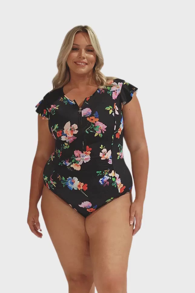 Model wearing black floral zip front frill sleeve swimsuit