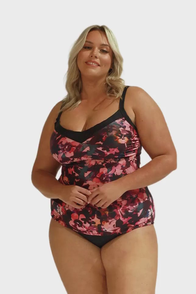 Model wearing pink and plum floral underwire tankini and black bottoms