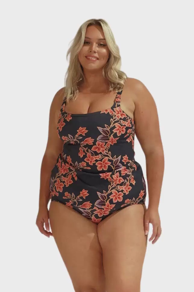 Model wearing navy and orange floral tankini and high waisted pant