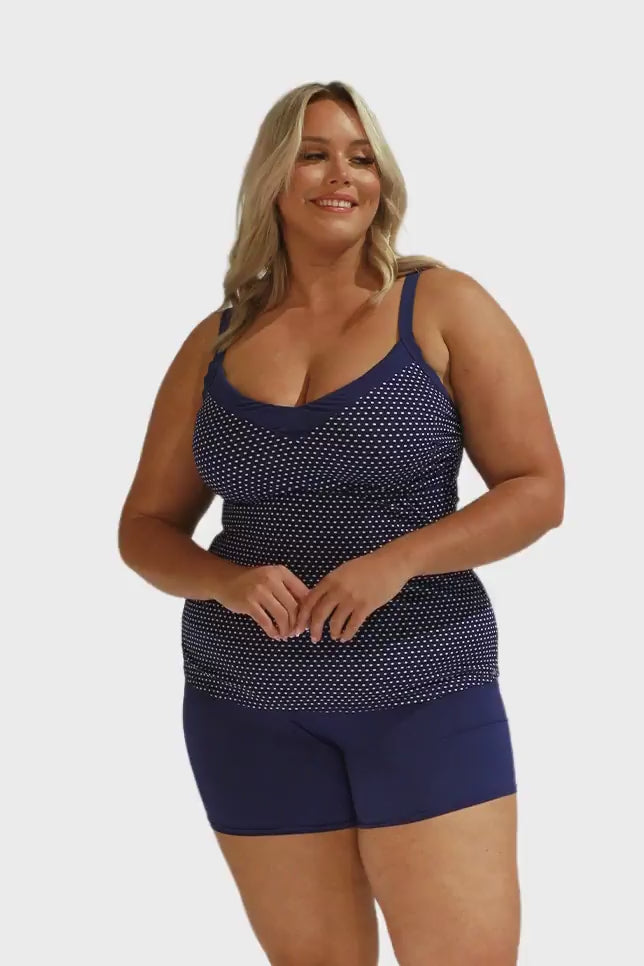 Model wearing navy and white dots underwire tankini and navy boyleg pant