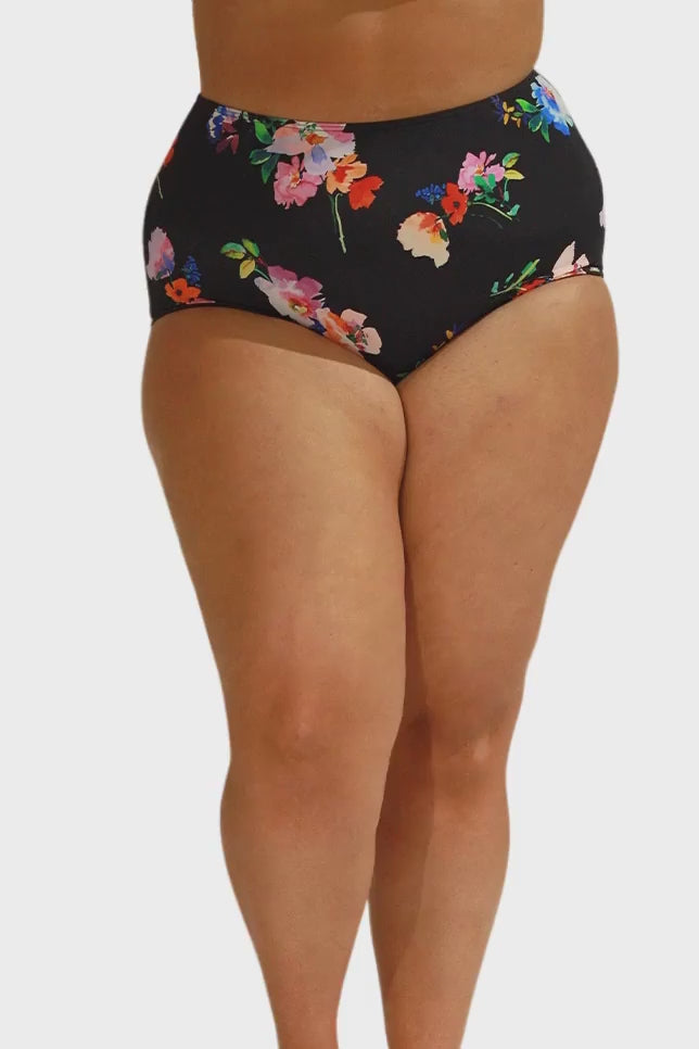 Model wearing black floral high waisted bikini bottoms